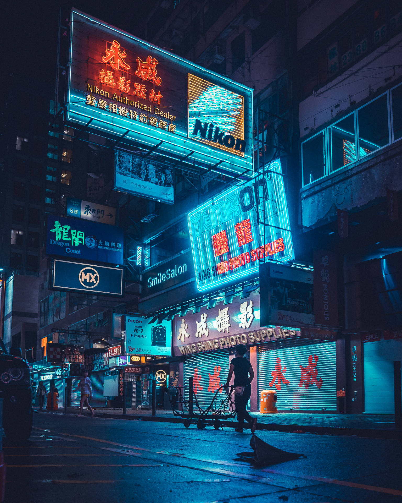 霓虹招牌照亮夜晚濕滑嘅街道，行人路過。