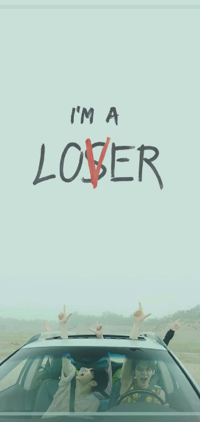 車內兩個人舉起手，文字「I'M A LOSER」中的「O」被紅色斜線劃掉。