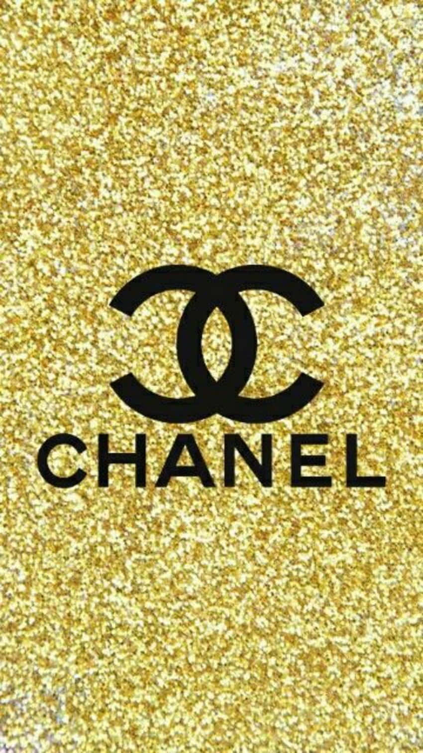 沉醉於香奈兒的經典優雅 壁紙 — 黑色 Chanel 標誌居中於閃爍的金色閃粉背景上。