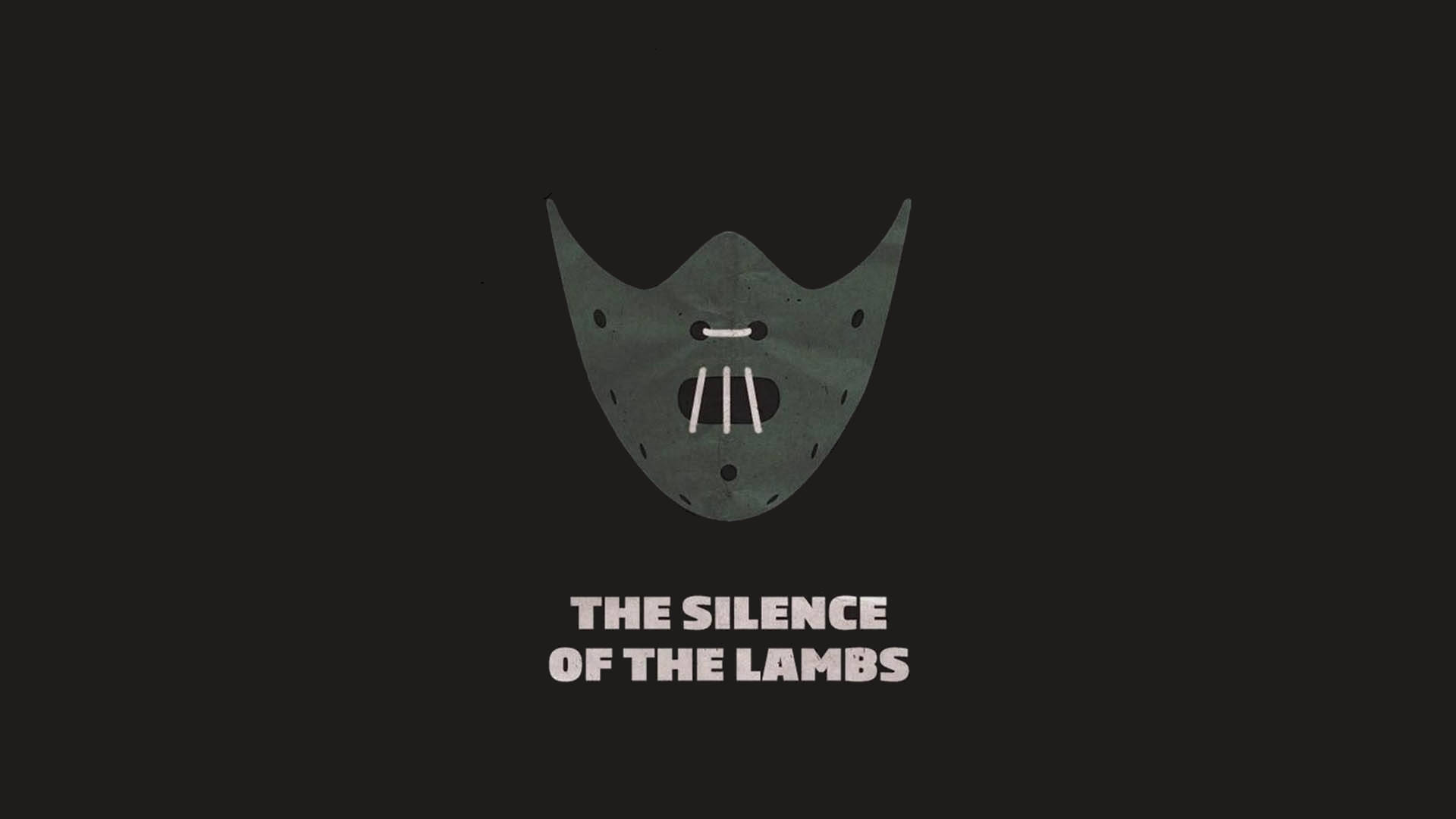 灰色面具，有三個牙齒和眼孔，在黑色背景上帶有白色文字「THE SILENCE OF THE LAMBS」