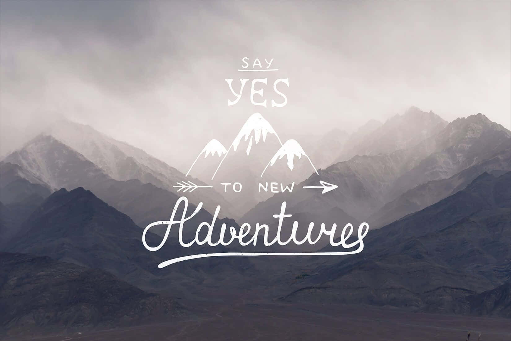 霧氣籠罩的山脈，白色文字「Say Yes to New Adventures」