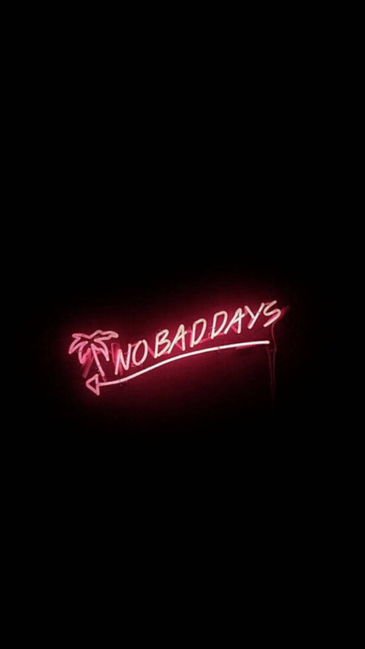 粉紅色霓虹燈牌寫著no bad days，帶有棕櫚樹設計，背景漆黑
