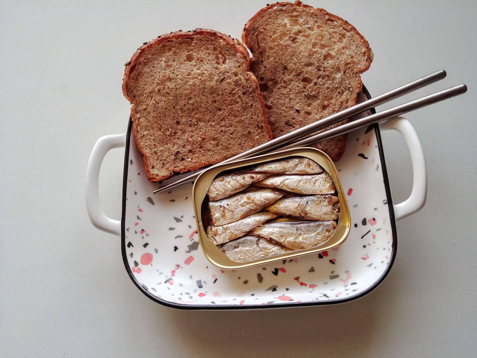 一碟麵包和沙甸魚，附筷子