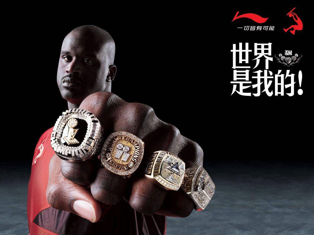 沙克·奧尼爾戒指 壁紙 — Shaquille O'Neal 在深色背景上展示他的冠軍戒指，背景有中文文字，眼神專注。
