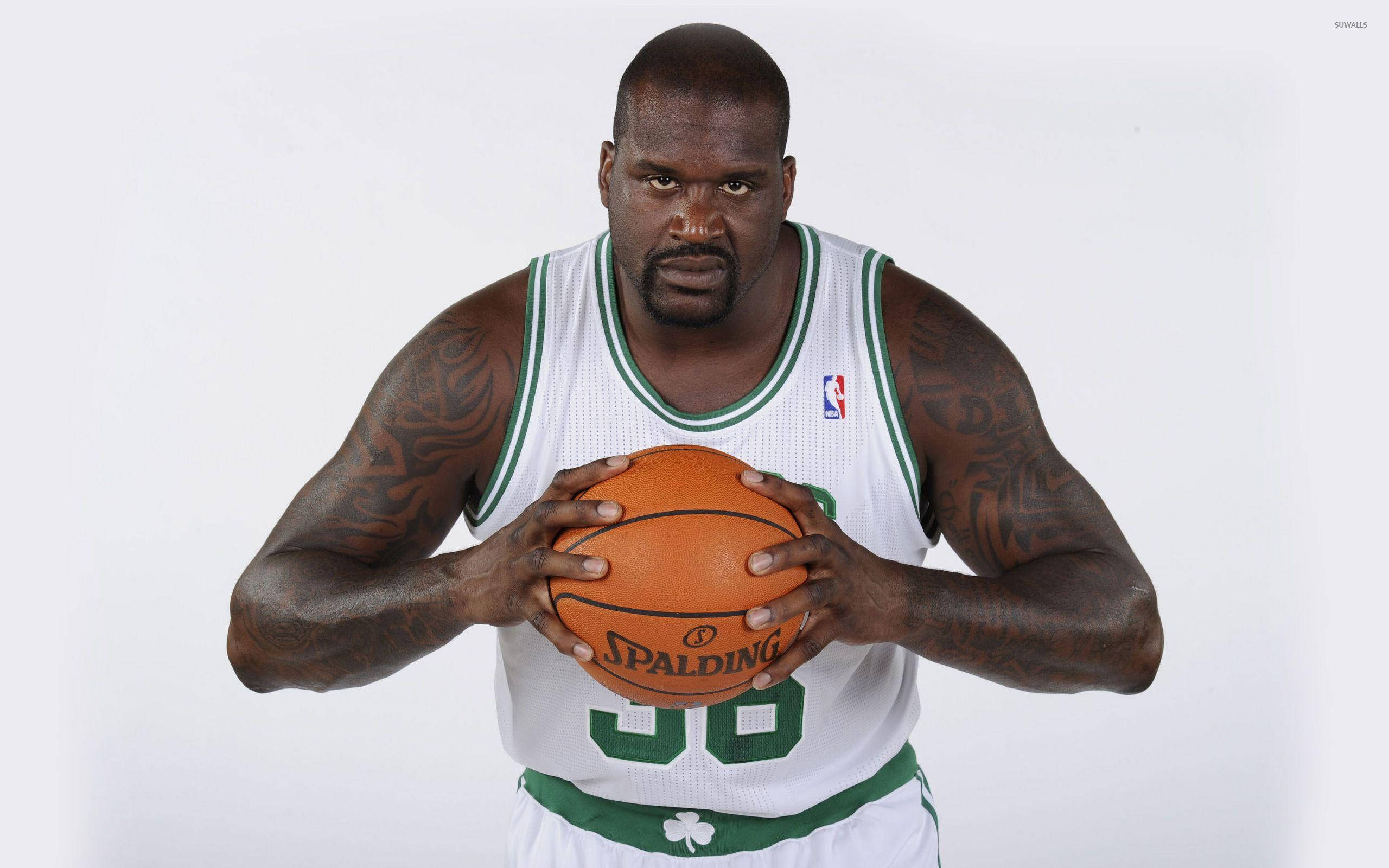 沙克·奧尼爾波士頓塞爾提克隊 壁紙 — Shaquille O'Neal 身穿波士頓塞爾提克球衣，在純白背景下專注地握著一顆 Spalding 籃球。