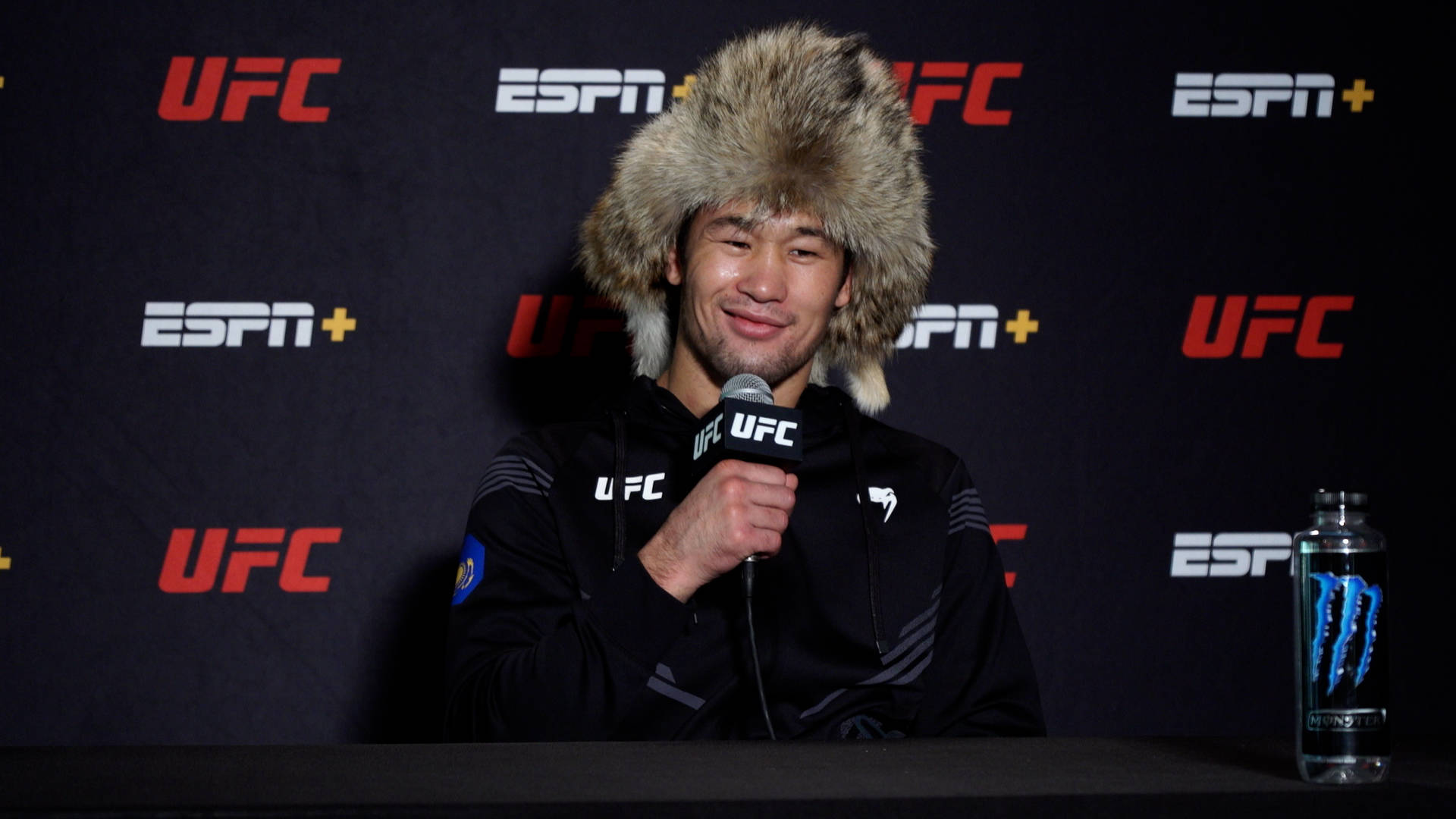 UFC拳手戴著毛帽在記者會上發言。
