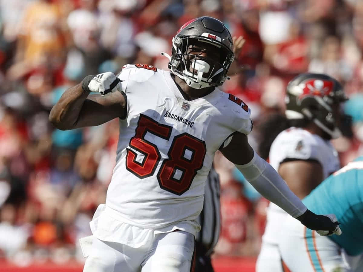 沙奎爾·巴雷特 坦帕灣海盜隊 NFL 壁紙 — 一名身穿白色58號球衣的坦帕灣海盜隊美式足球員在陽光明媚的球場上充滿活力地慶祝，身後是模糊的體育場人群。