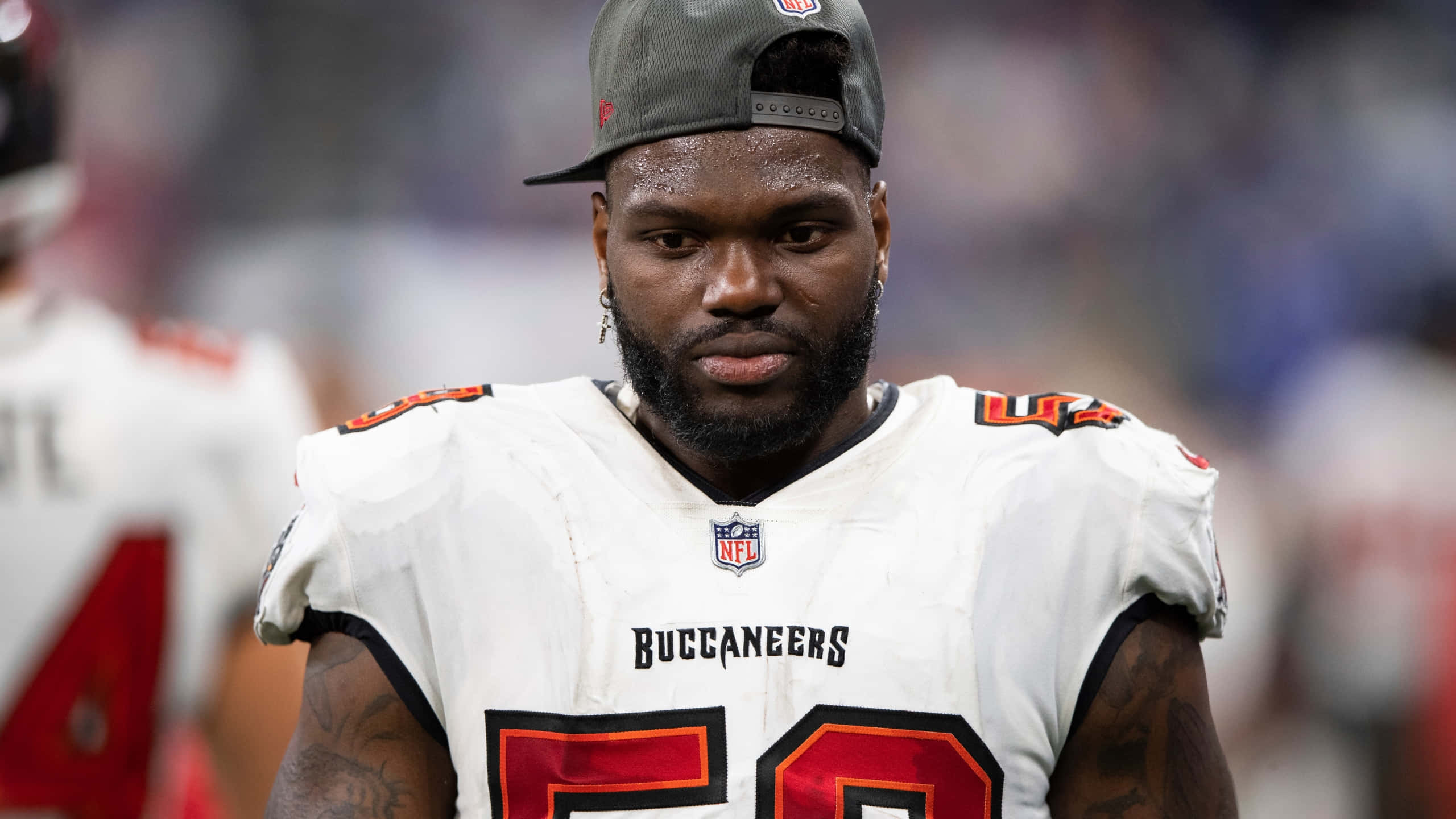 沙奎爾·巴雷特 坦帕灣海盜隊 NFL 壁紙 — 一名專注的坦帕灣海盜隊美式足球員，身穿白色球衣，背號50，在球場燈光下比賽時凝視著前方。