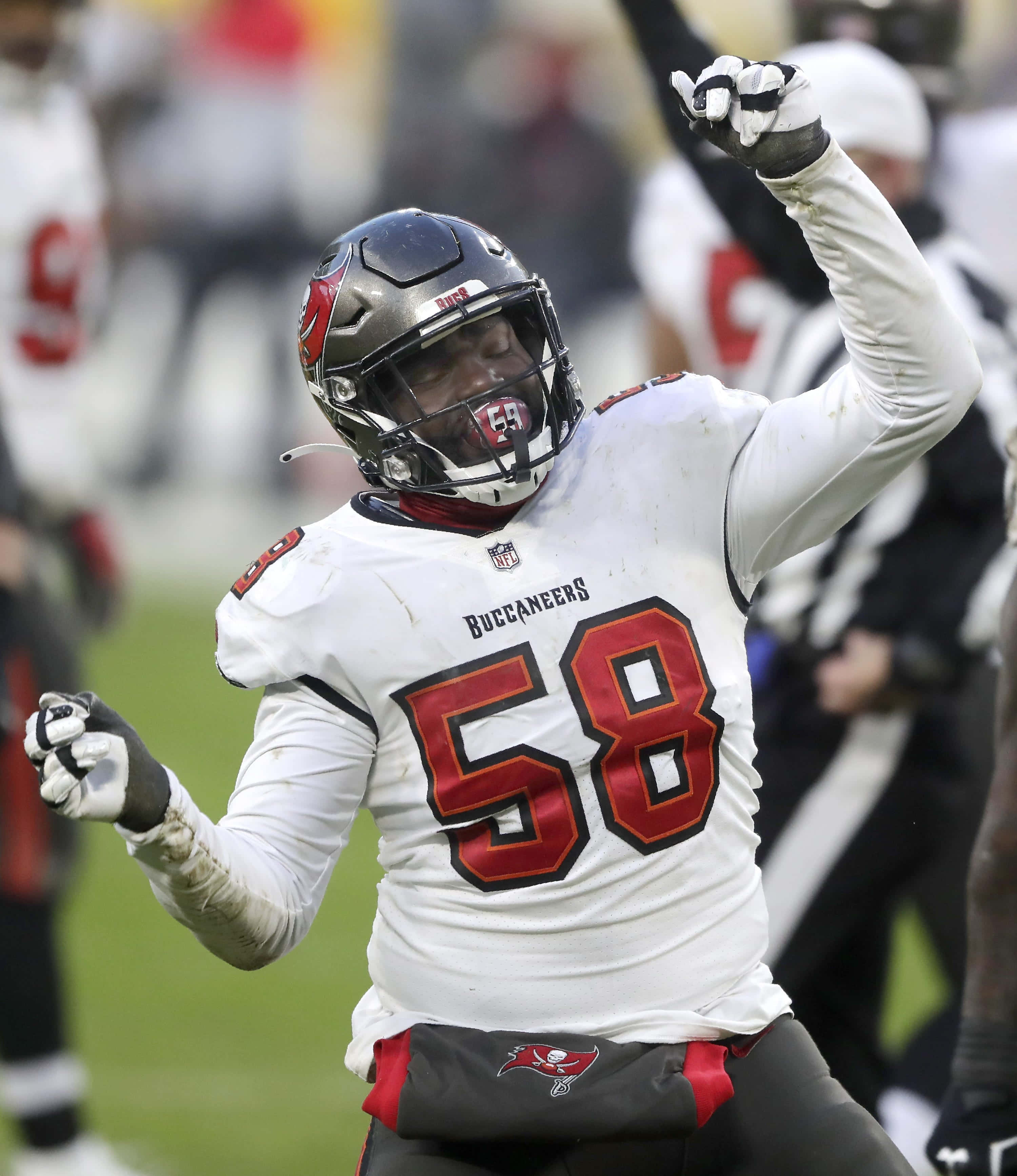 沙奎爾·巴雷特 舞蹈 NFL球員 壁紙 — 一名身穿白色58號球衣的坦帕灣海盜隊美式足球員在綠色球場上舉拳慶祝。
