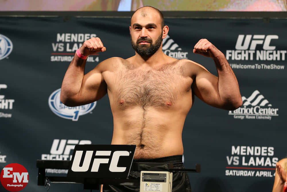 UFC拳手在稱重活動中在磅秤上屈起雙臂。