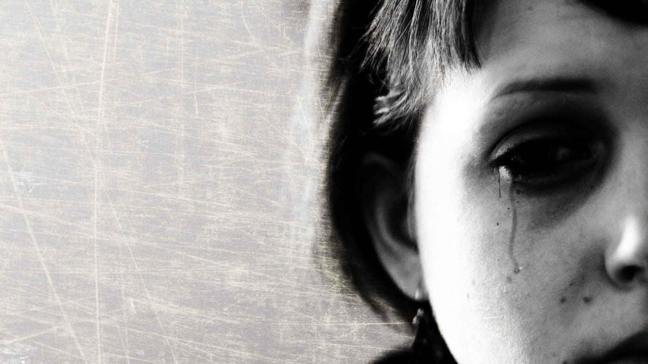 一個年幼的孩子在黑白畫面中哭泣，淚水順著臉頰滑落。