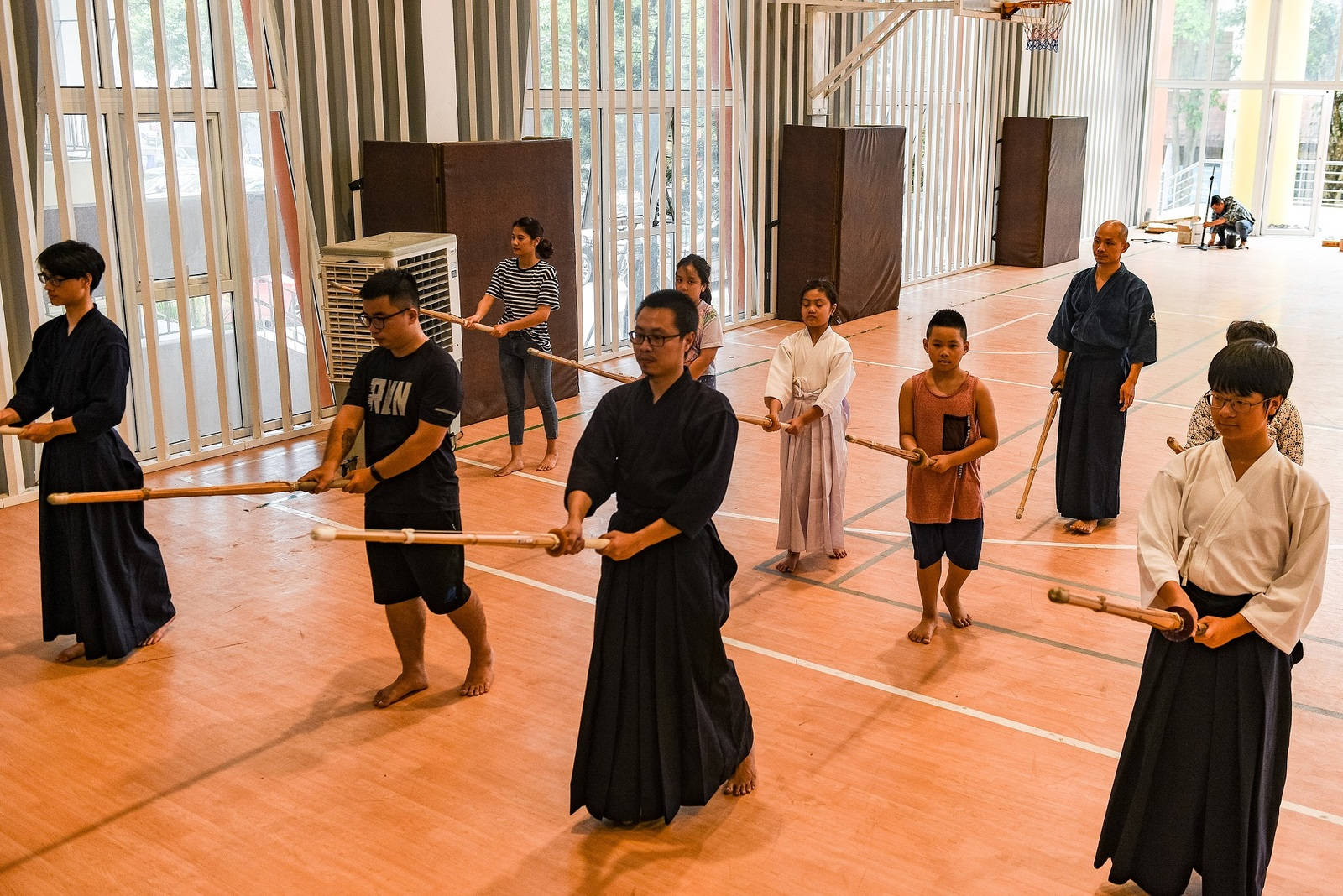 學生在體育館用木劍練習武術。