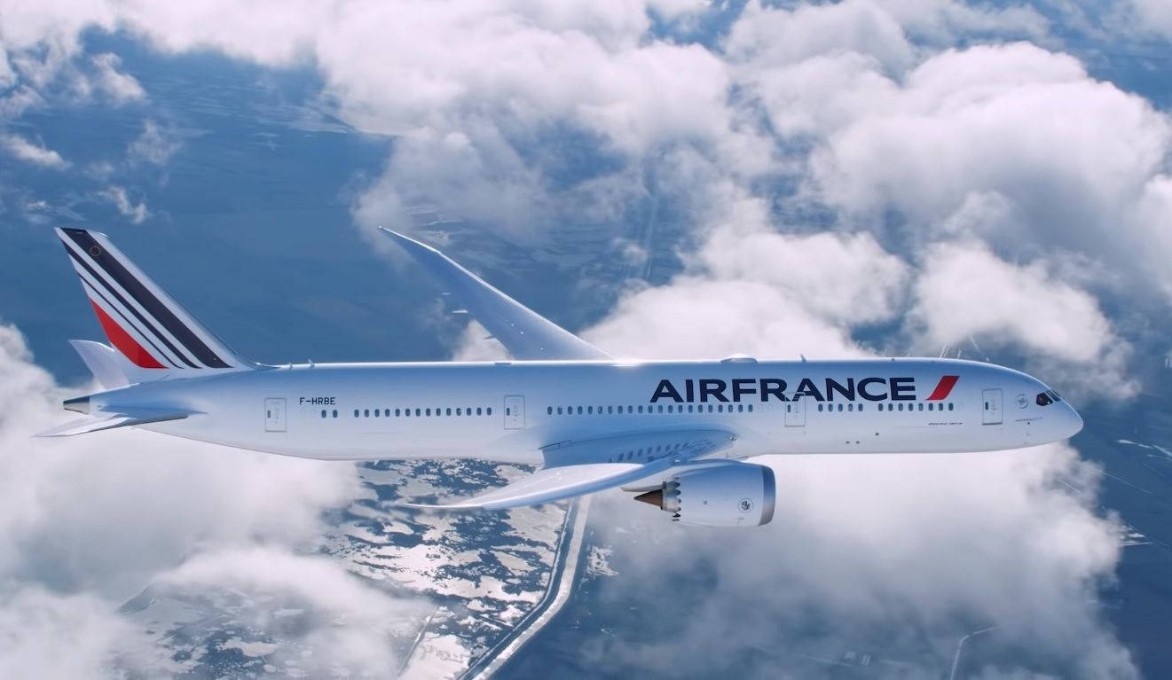 法國航空飛機在雪地上空雲層上方飛行，有道路。