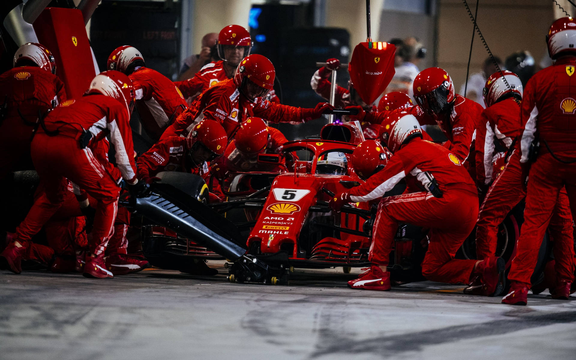 法拉利F1維修人員在車庫中更換5號賽車的輪胎。