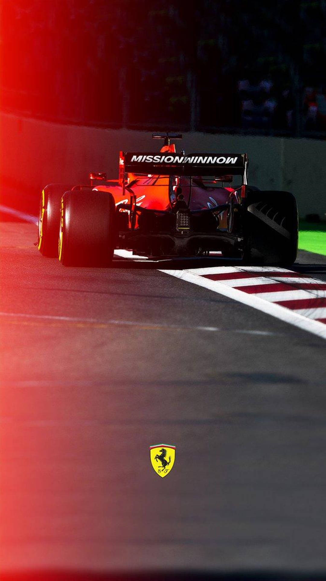 法拉利F1賽車在夜間賽道上奔馳，伴隨紅色燈光。