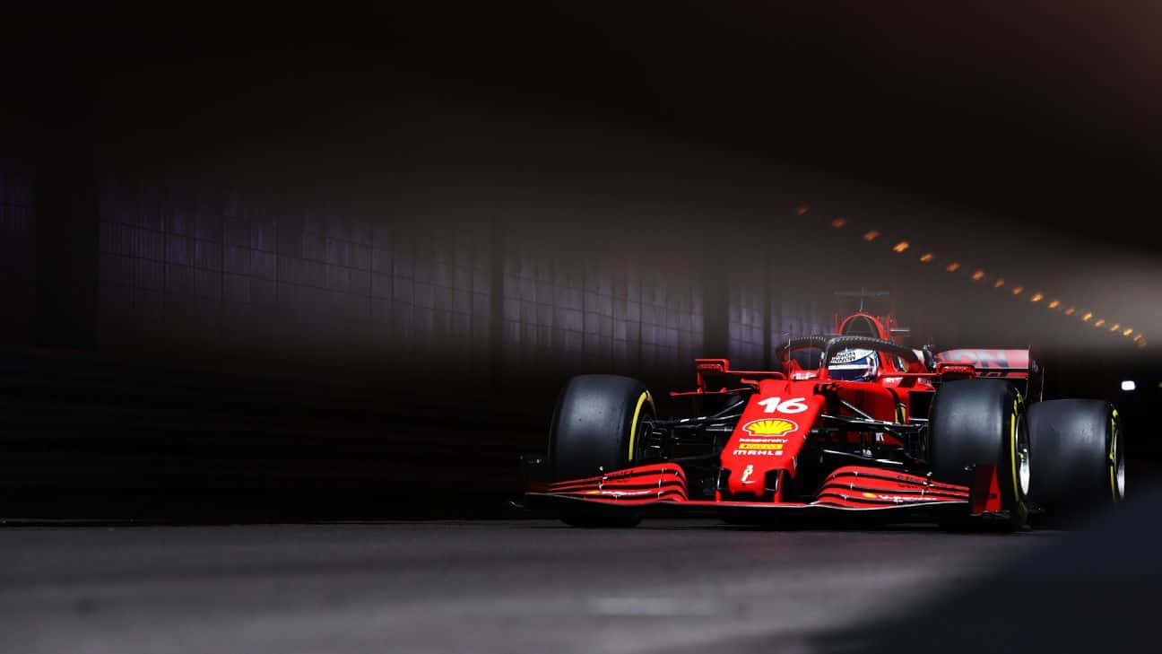 紅色法拉利F1賽車在黑暗隧道中疾馳，上方有發光的燈光。