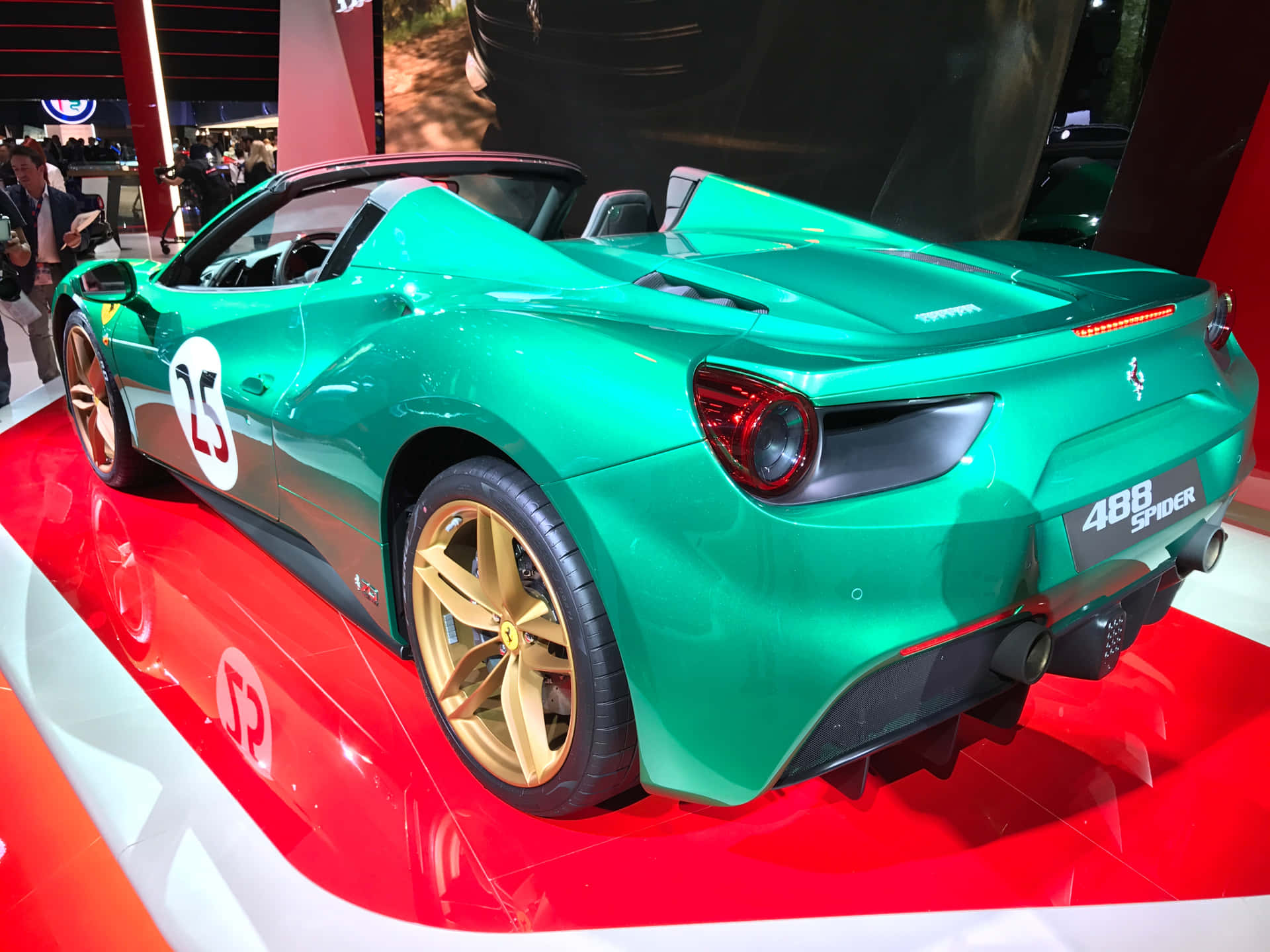 車展上紅色展台上的綠色法拉利488 Spider開篷跑車。