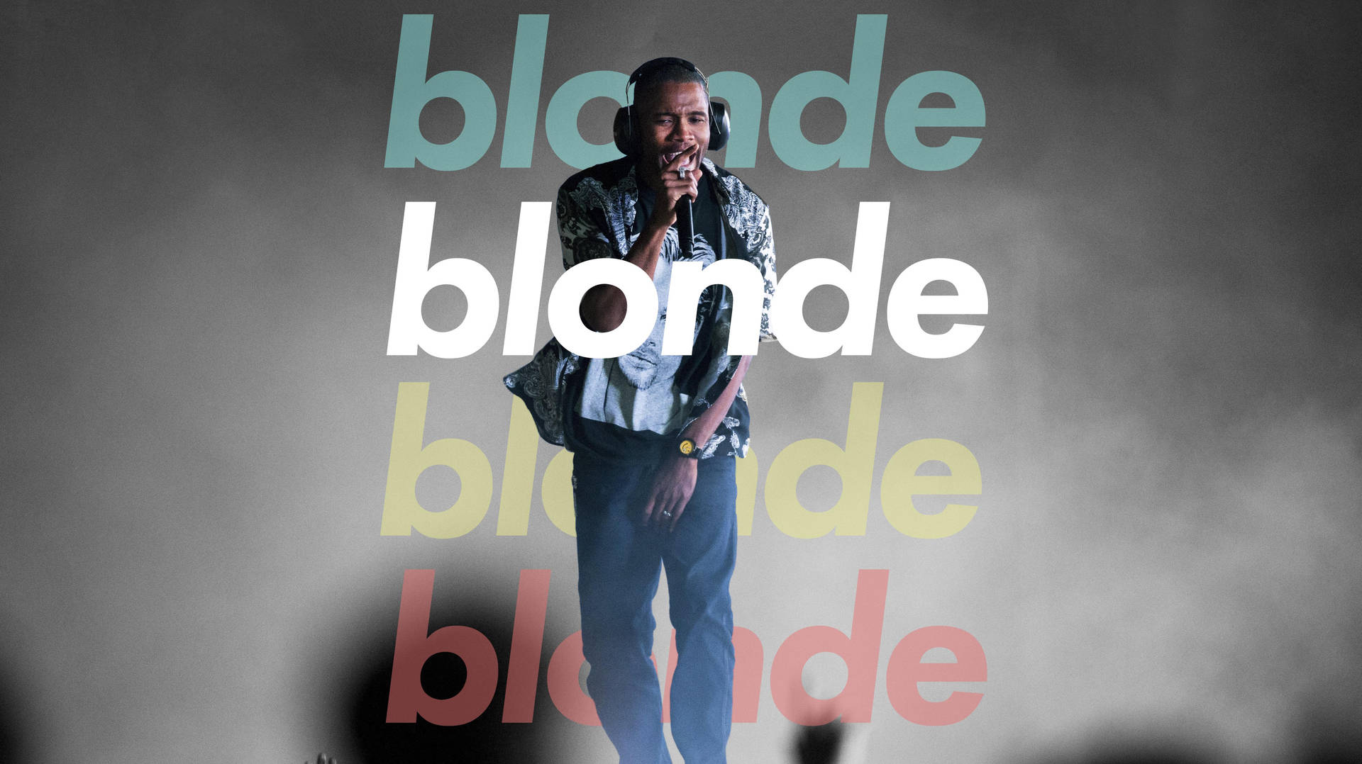 戴著耳機的歌手在煙霧繚繞的舞台上表演，身後有分層的「blonde」文字。