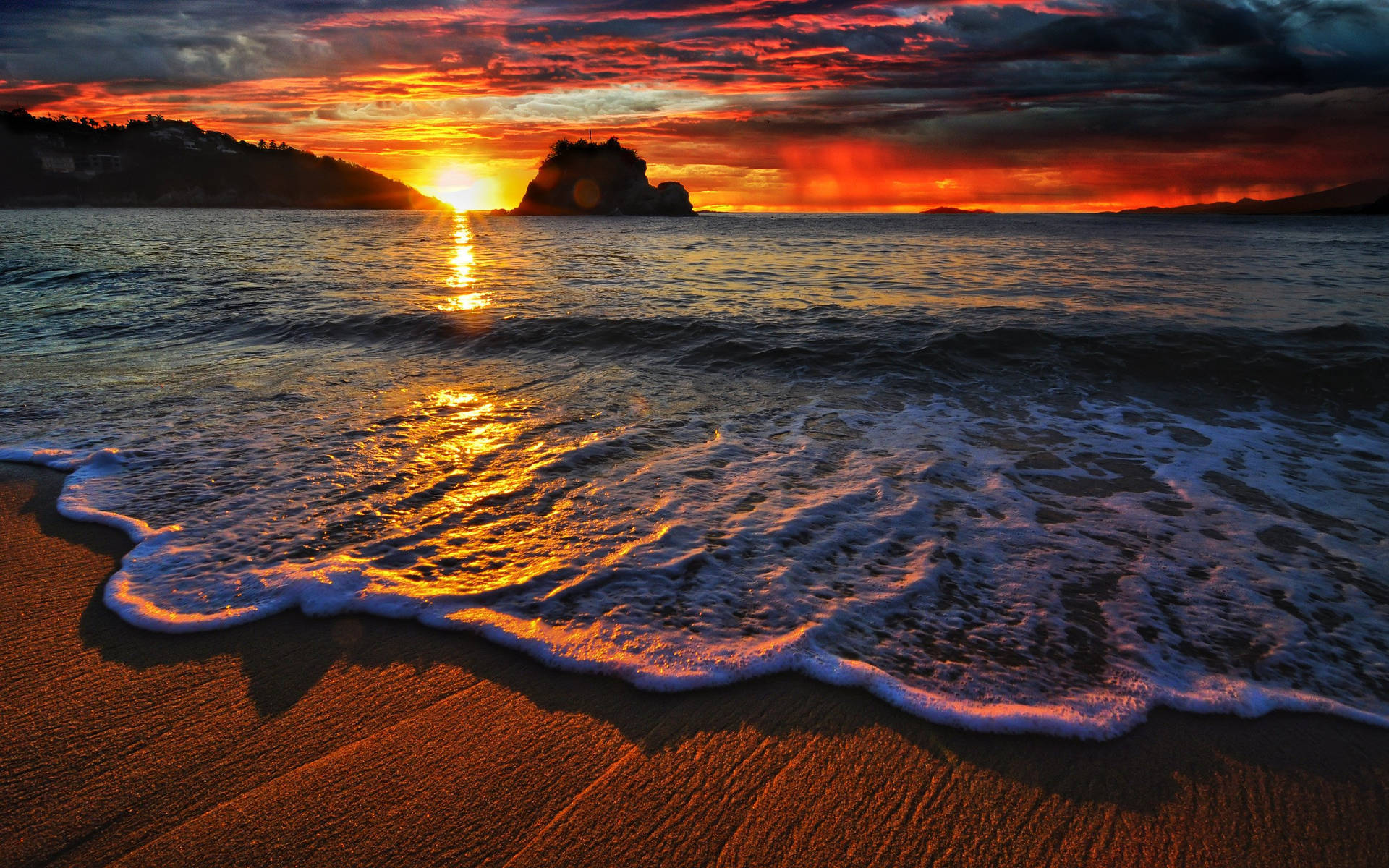 海洋上的夕陽，海浪沖刷沙灘和遠處的岩石島嶼