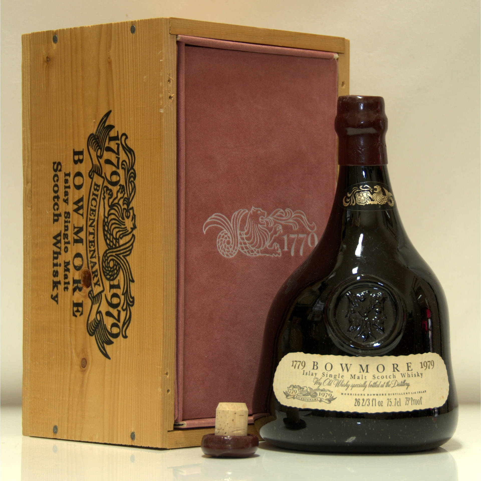 一瓶復古 Bowmore 威士忌，附有木盒和軟木塞，置於反光表面上。