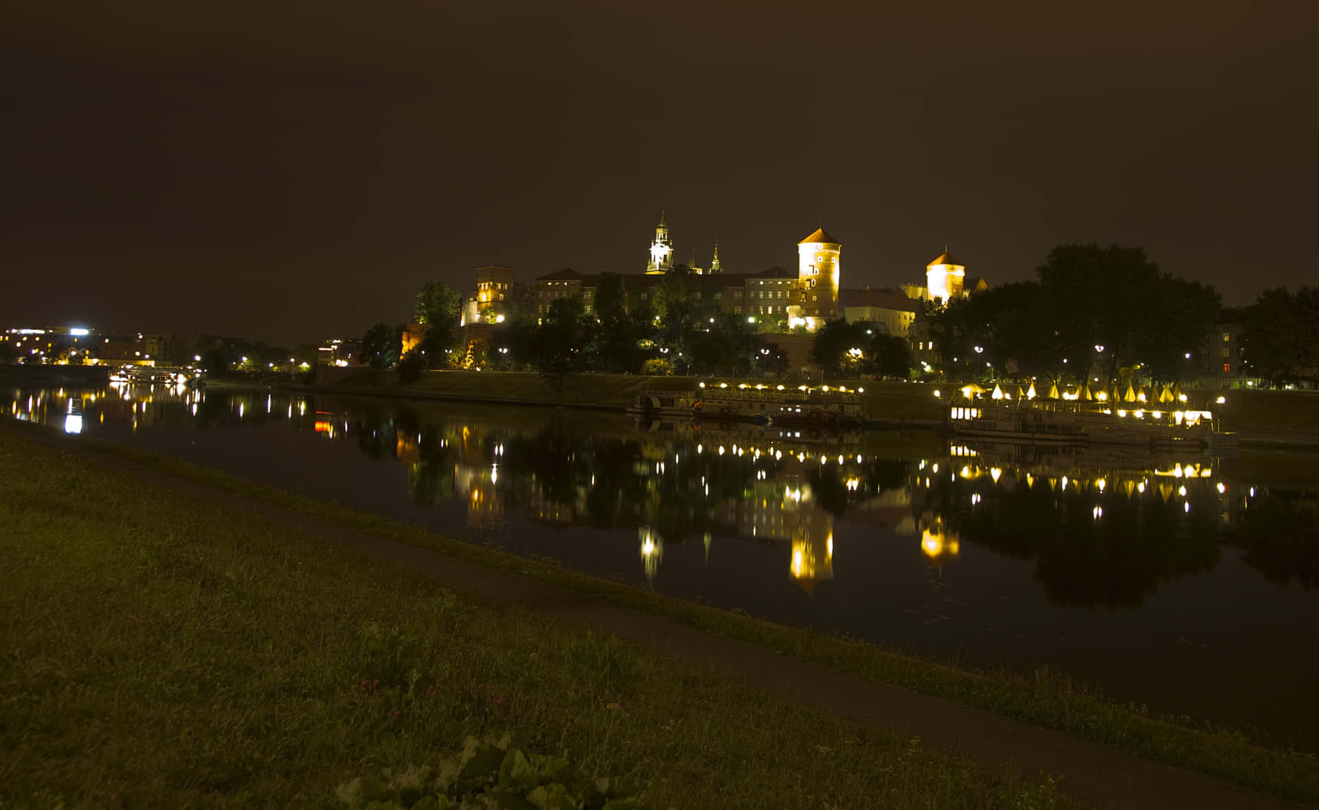 城堡倒映在河中的夜景，伴有燈光小徑。