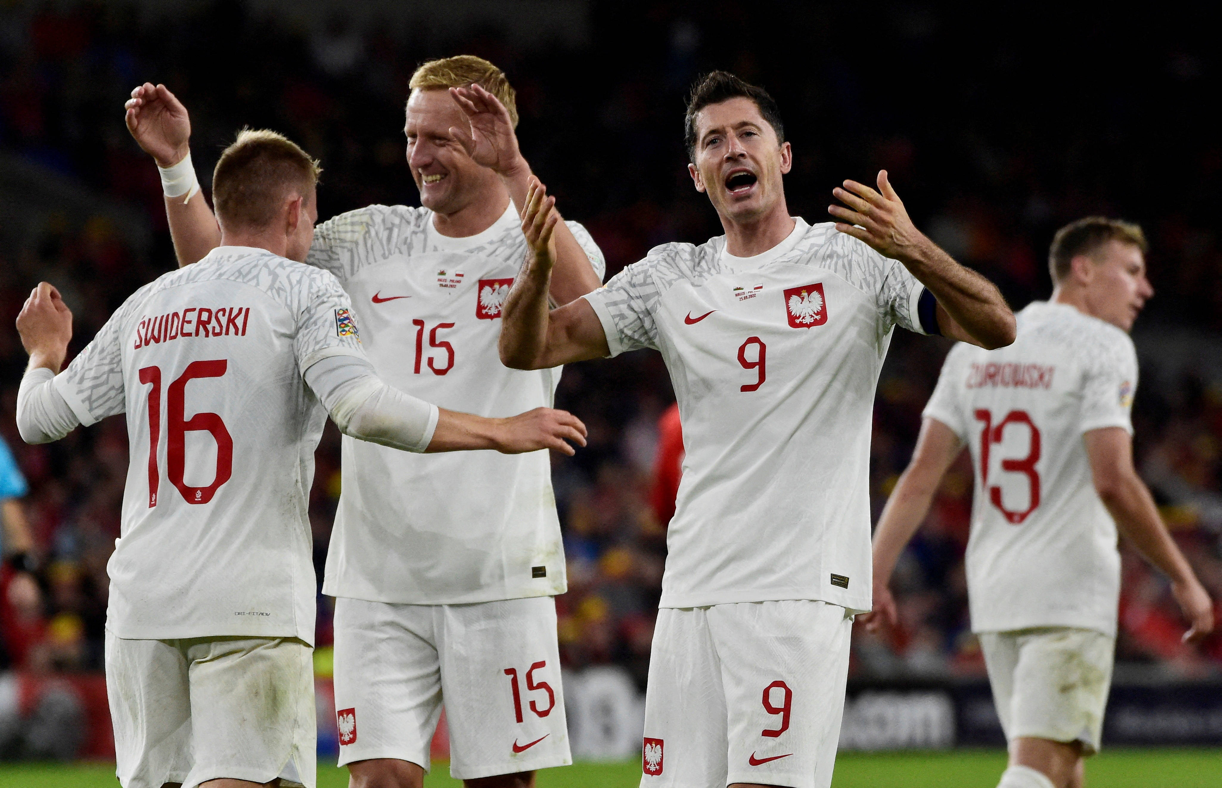 World 桌布 壁紙 — 波蘭足球運動員身穿白色球衣，在球場上高舉雙臂，面露喜悅，慶祝入球。