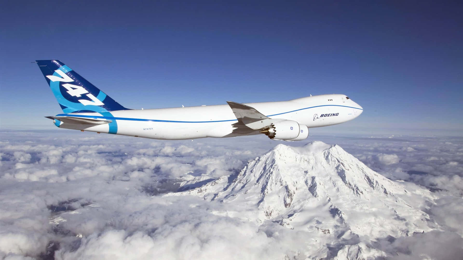 波音747飛越雲層上方的雪山峰
