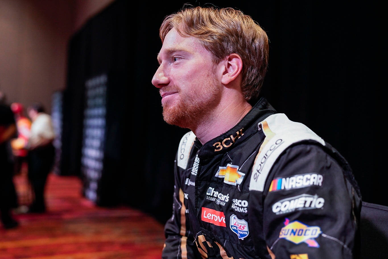 NASCAR車手身穿賽車服在室內微笑