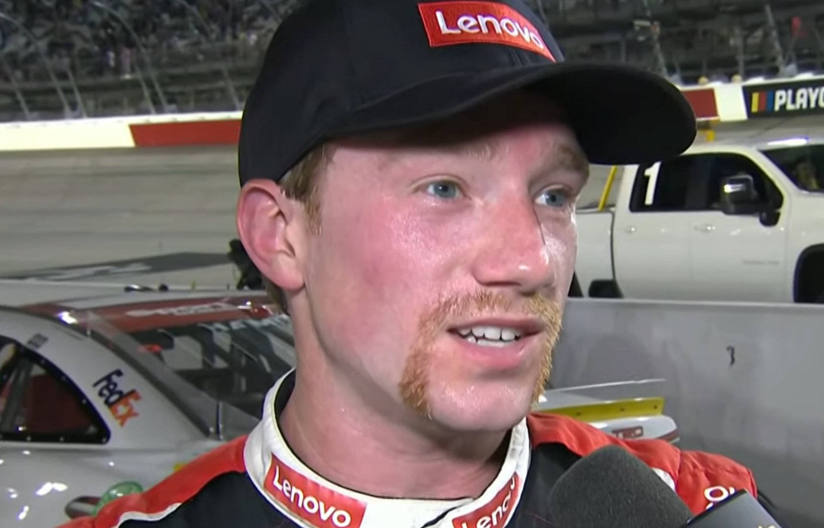 身穿Lenovo裝備的NASCAR車手在賽車場接受訪問。