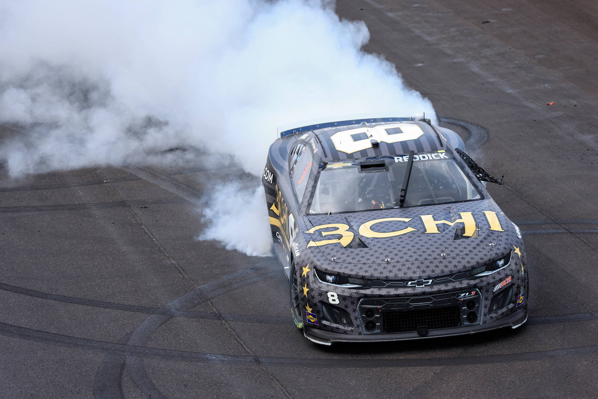 NASCAR賽車在賽道上進行燒胎表演，煙霧瀰漫
