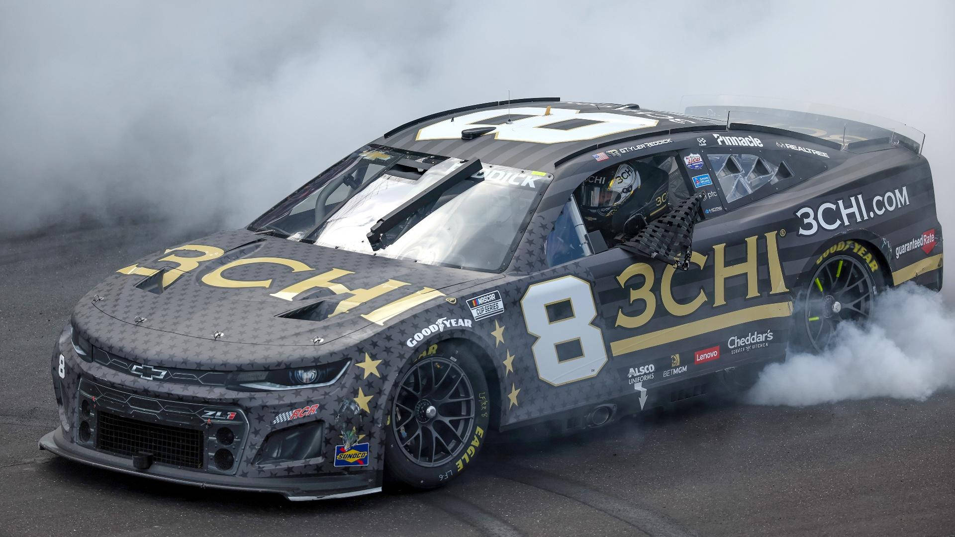 黑色和金色NASCAR賽車在賽道上飄移冒煙