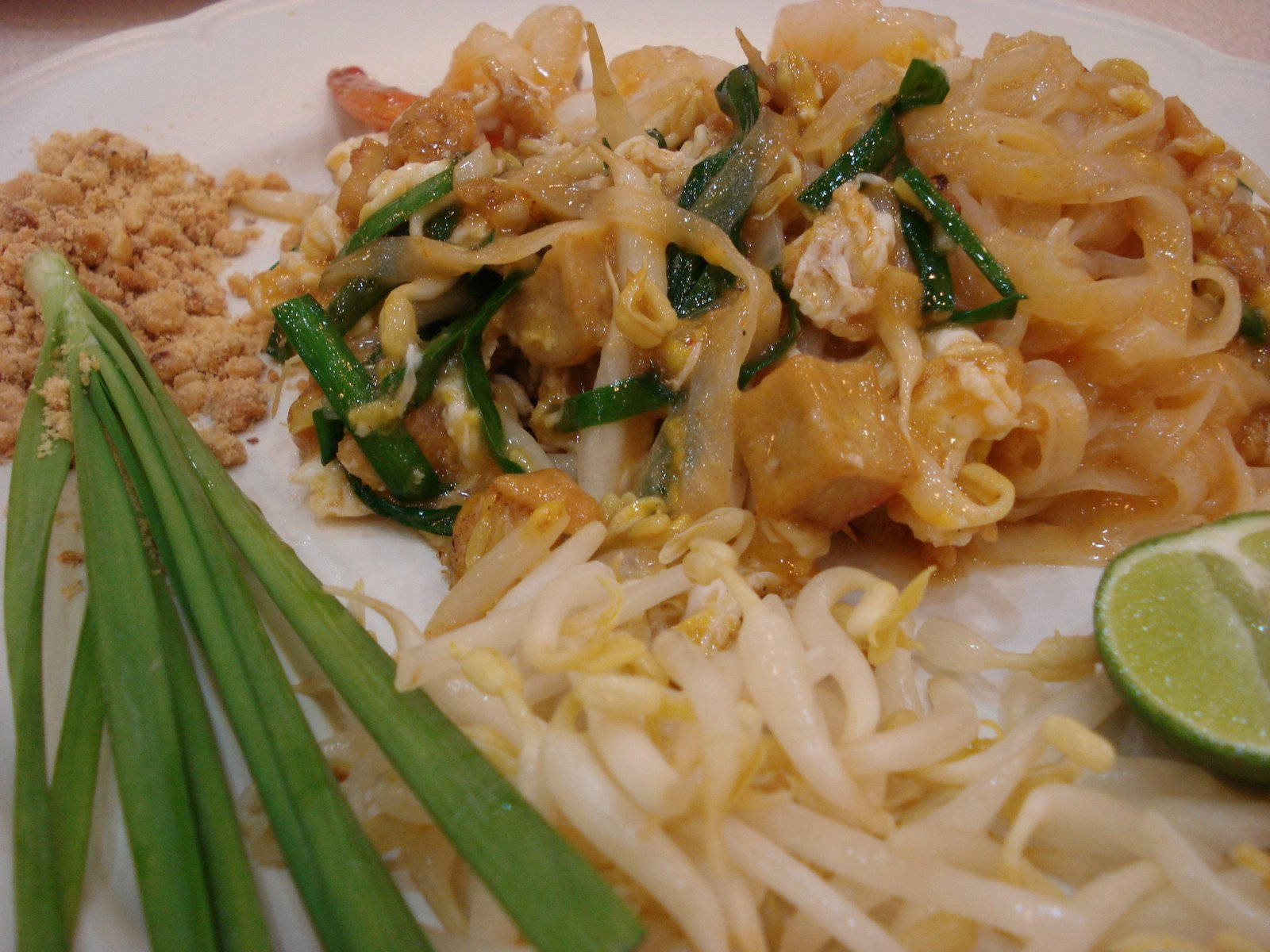 泰式炒河粉配上蝦、豆腐、芽菜、青蔥、花生和青檸。