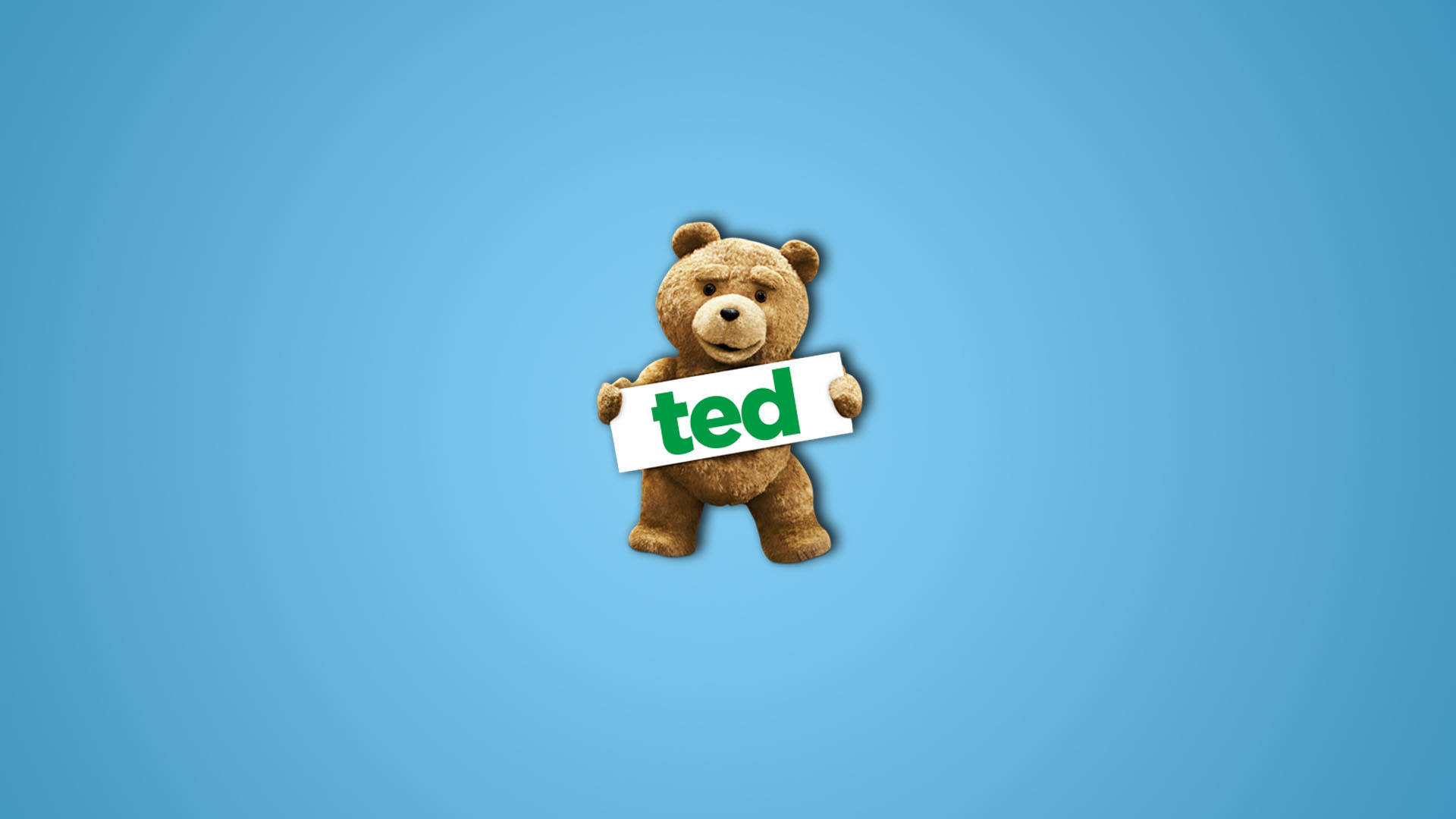 一隻棕色泰迪熊拿著一個寫著 ted 的標牌，背景為藍色。