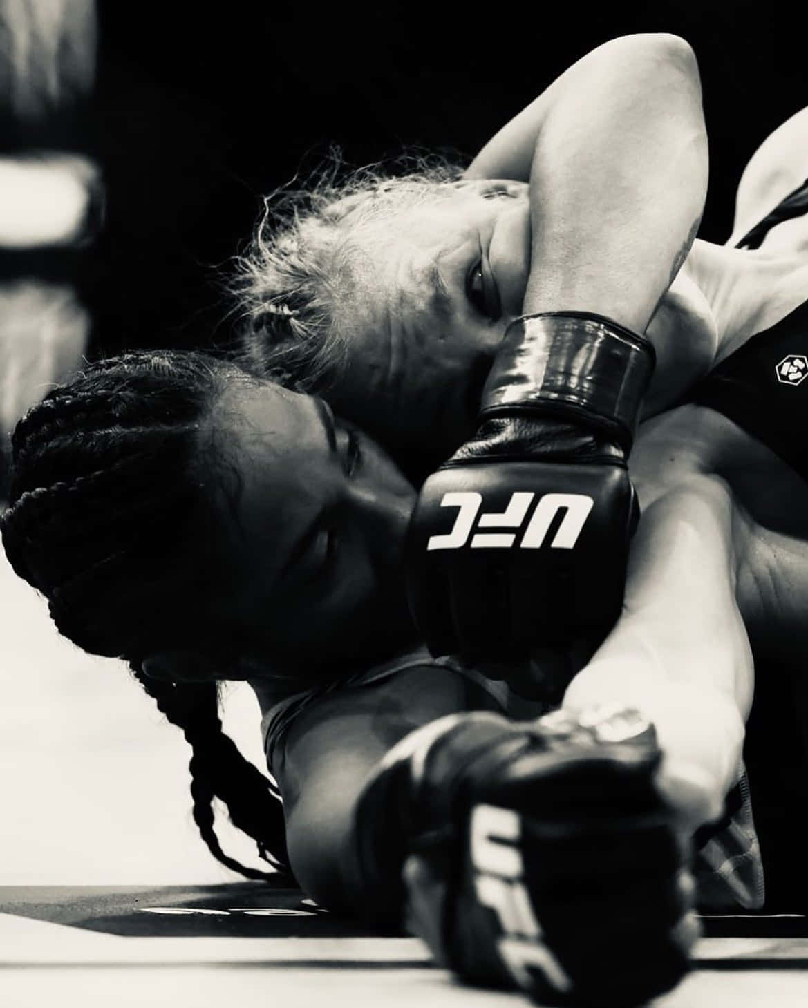 兩位女性MMA拳手在纏鬥比賽中穿著UFC手套。