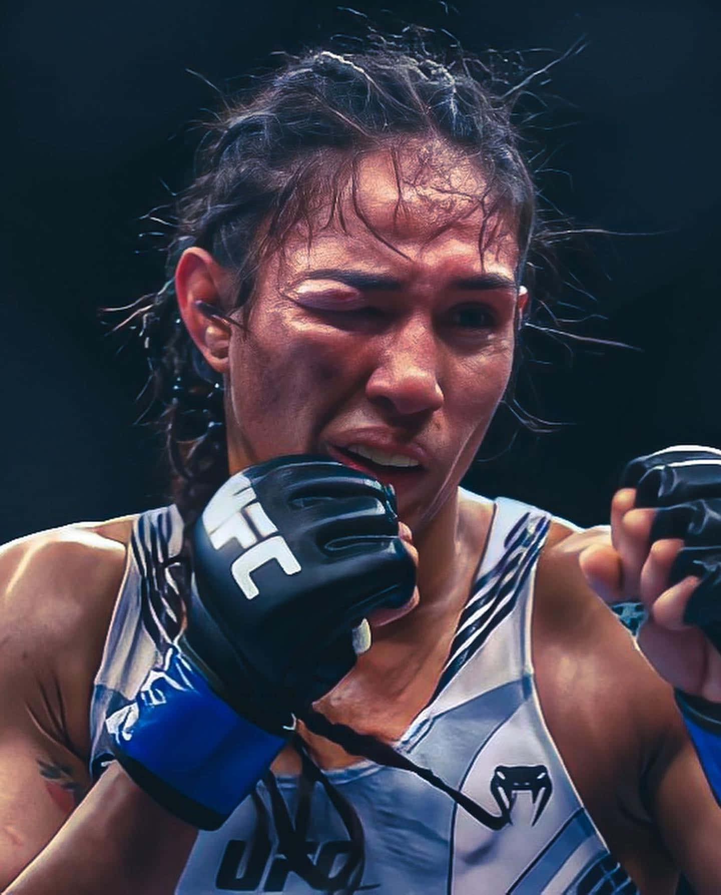 身穿UFC裝備的女性MMA拳手在比賽中展現決心。