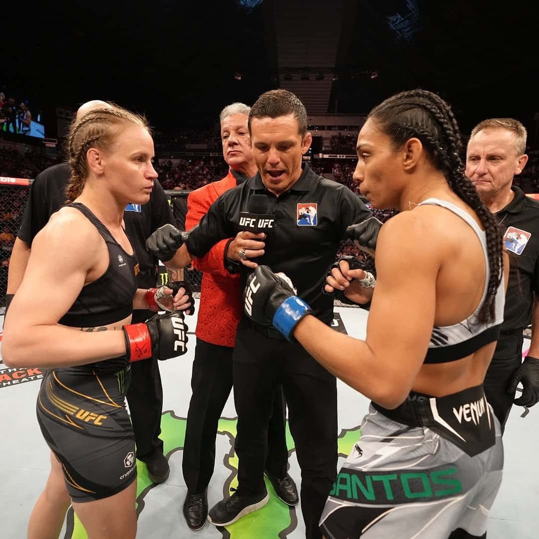 兩名女性MMA拳手以戰鬥姿勢在UFC八角籠中面對面，裁判在旁。