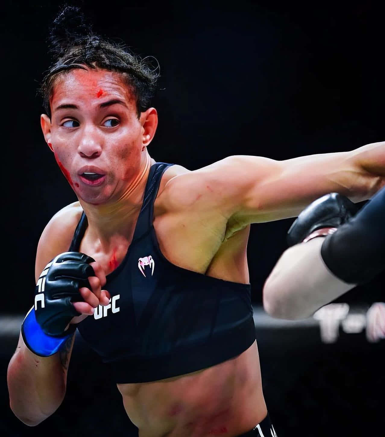 女MMA拳手臉上帶血揮拳。