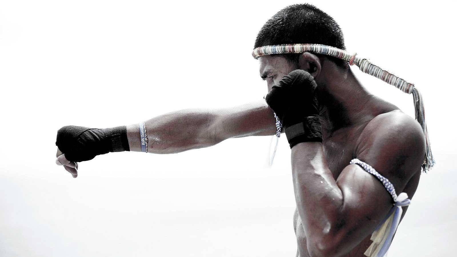 一位穿著傳統裝備的泰拳拳手打出一拳。