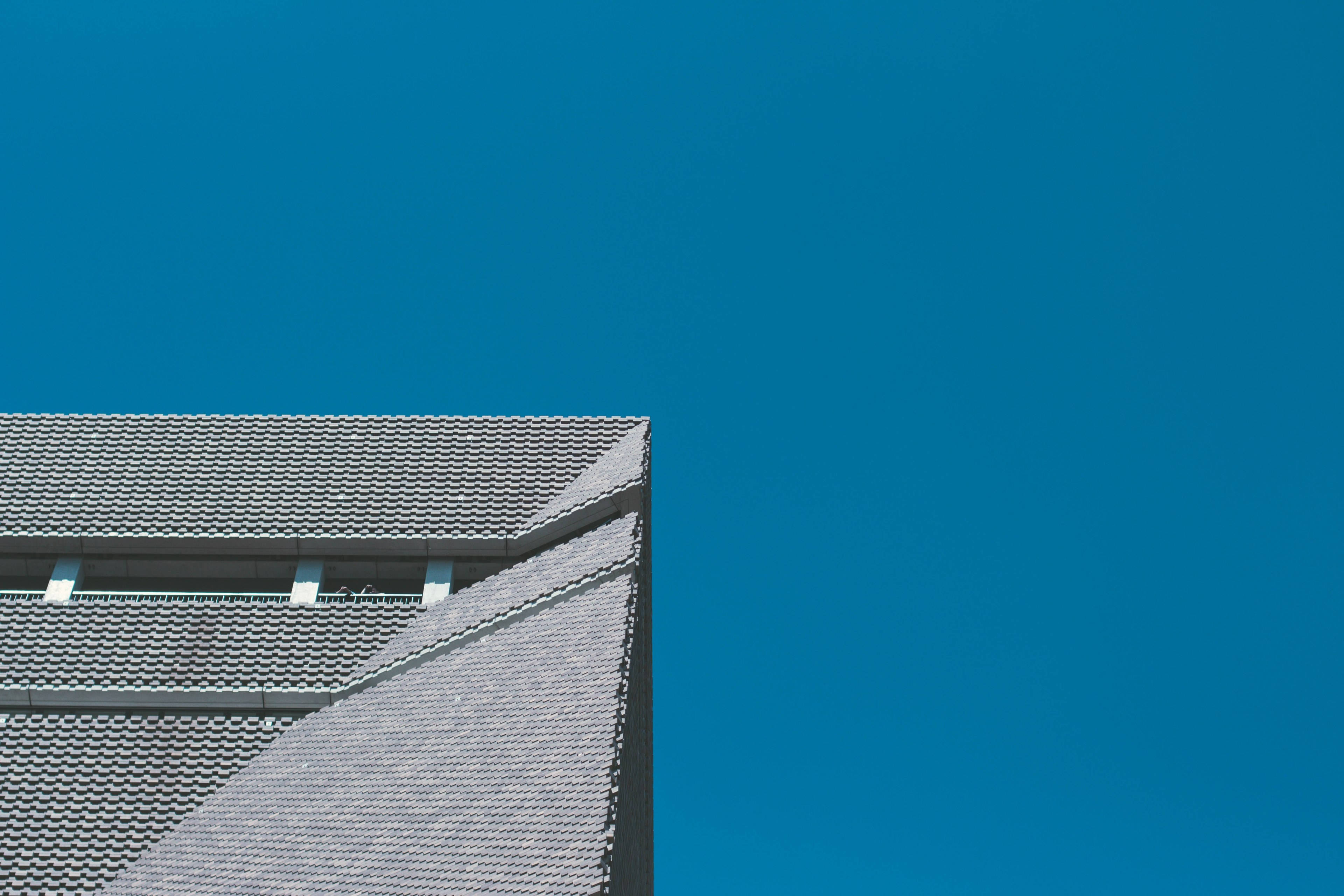 泰特現代藝術館建築屋頂 壁紙 — 現代建築的銳利幾何屋頂線條，在極簡建築攝影中與鮮豔的藍天形成對比。