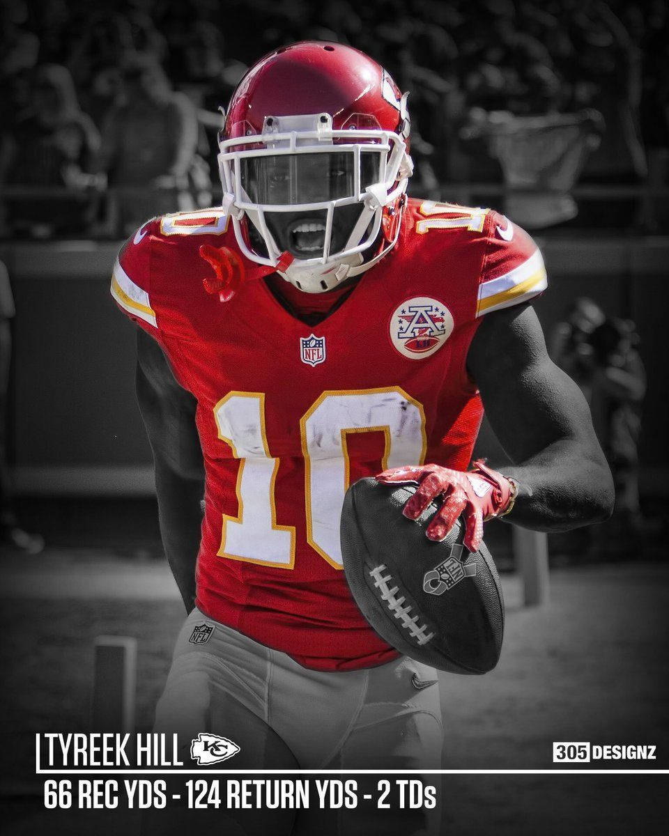 美式足球員Tyreek Hill身穿紅色10號球衣帶著足球奔跑。