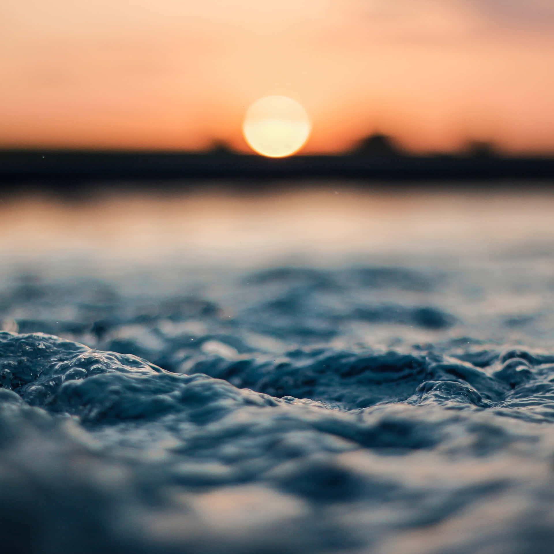 夕陽下的海洋，前景有質感的波浪