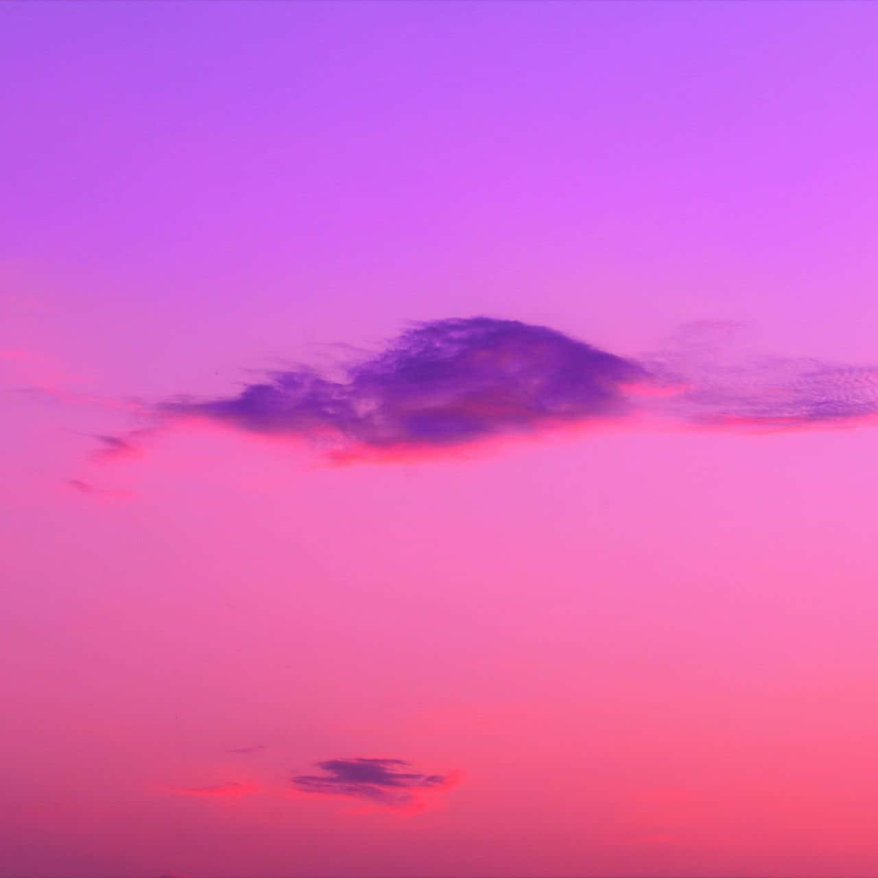 日落時分粉紅和紫色的天空，帶有柔和的雲朵