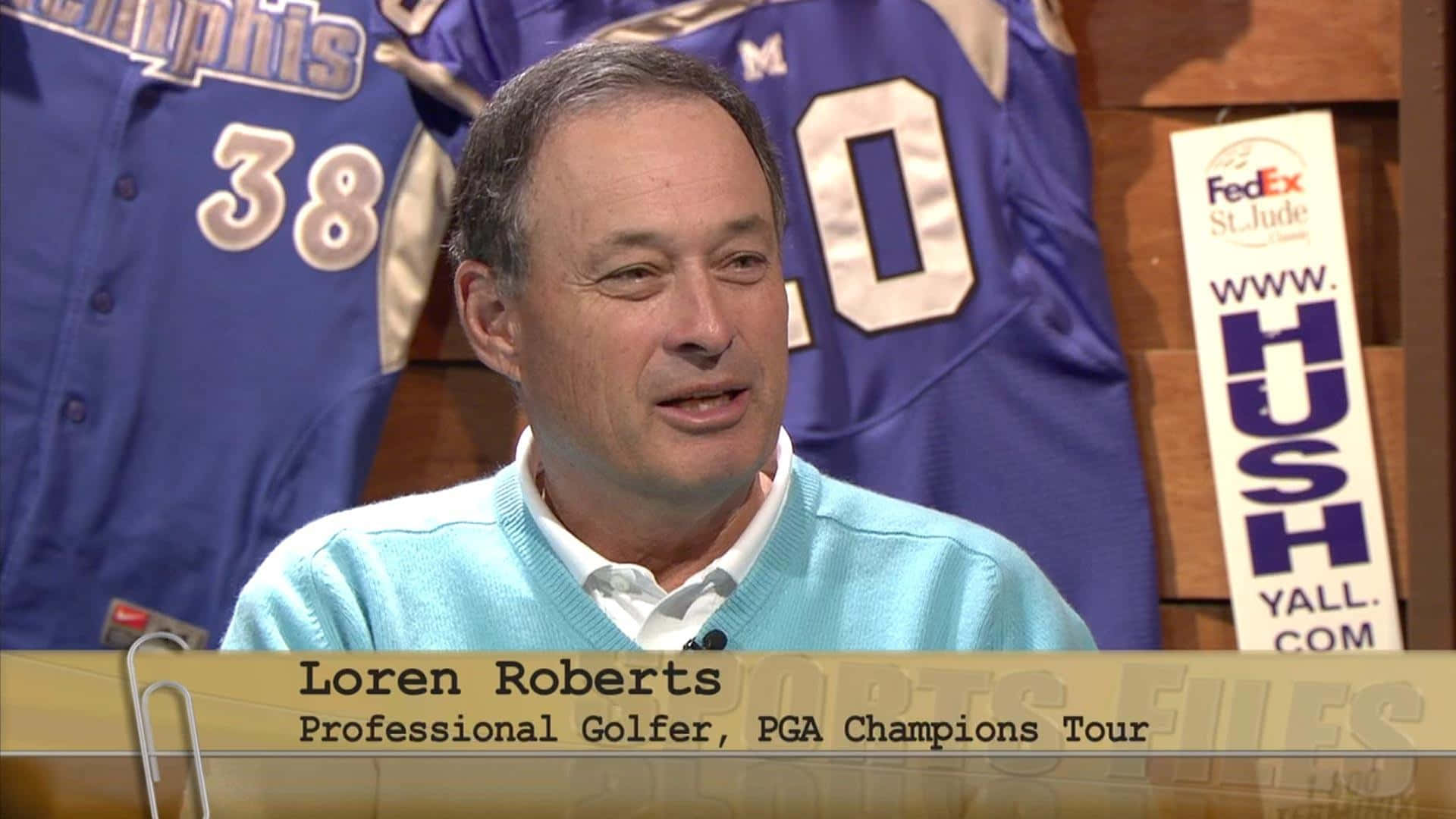 Loren Roberts 職業高爾夫球手在錄影室中發言，背後有運動球衣。