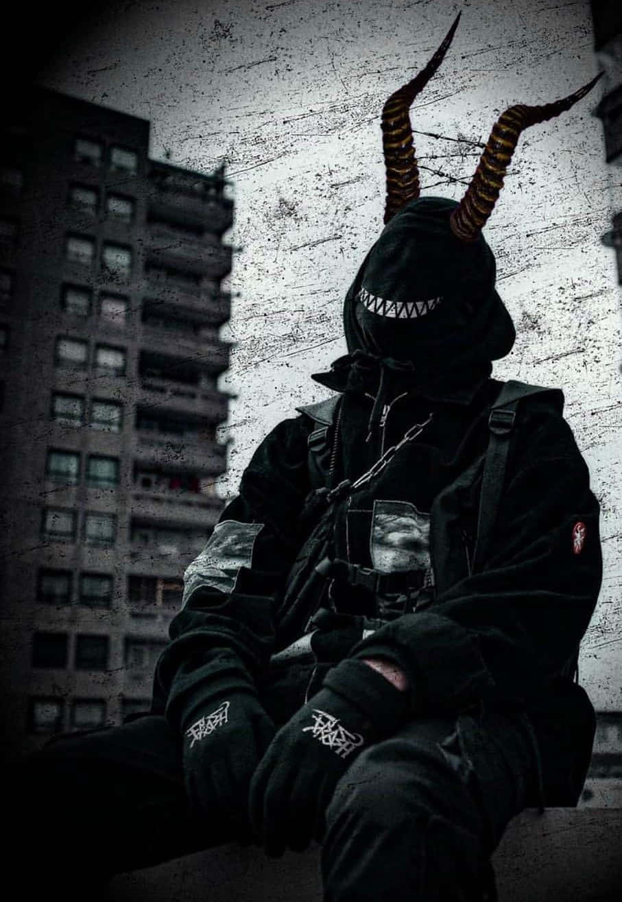 一個有角的連帽人物穿著深色城市街頭服飾坐在屋頂上。