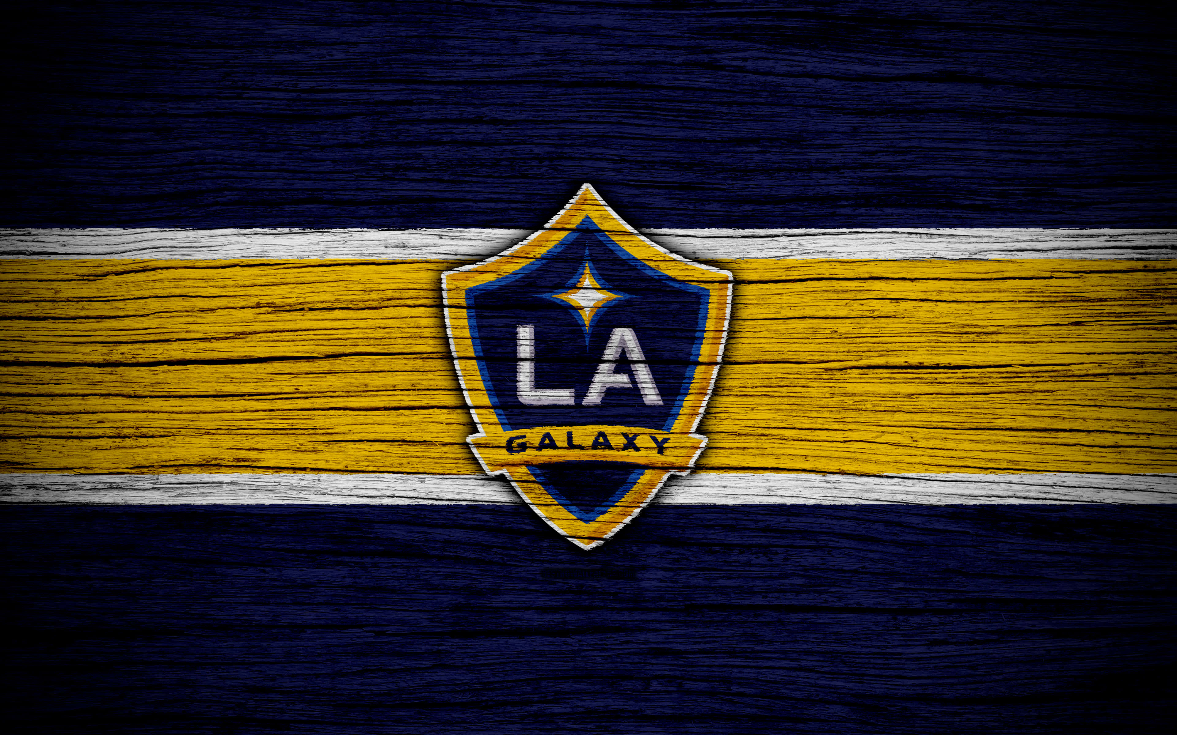 洛杉磯FC 4K木紋主題隊徽 壁紙 — LA Galaxy 足球隊標誌置於風化木質表面中央，搭配大膽的黃藍條紋。
