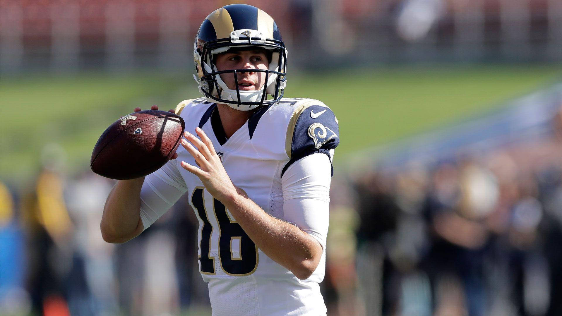洛杉磯公羊隊賈瑞德·高夫位置 壁紙 — 一位專注的NFL四分衛身穿白色公羊隊球衣，在日間比賽中準備擲出橄欖球。