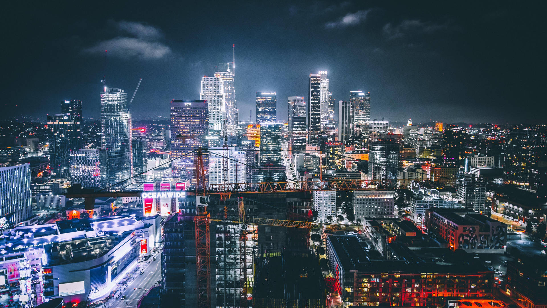 夜晚繁華的城市，燈光明亮，建築高聳。