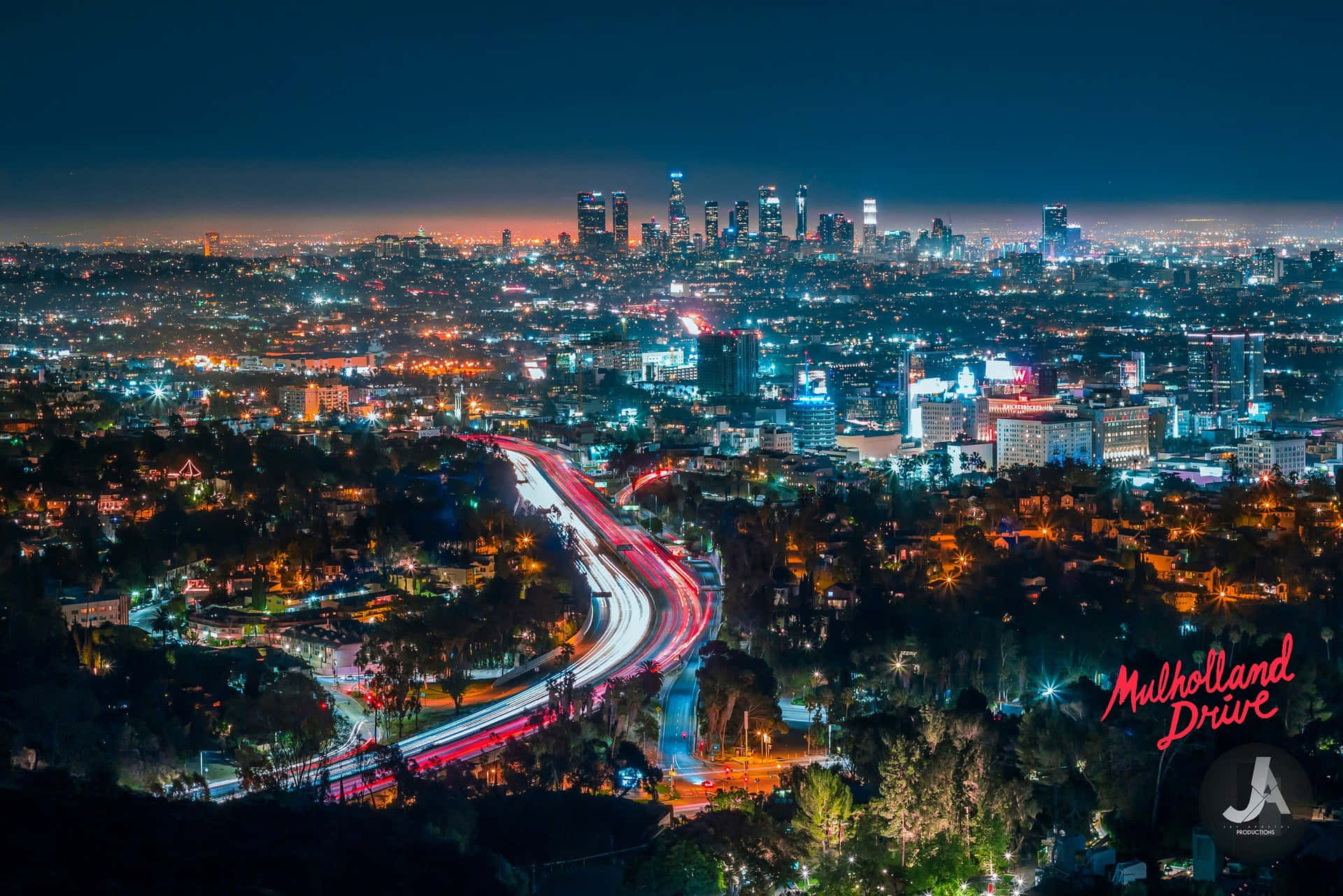城市夜景，有明亮的燈光和彎曲道路上移動的汽車。
