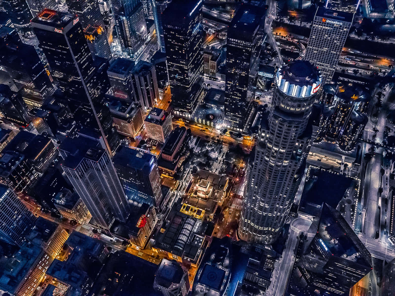 夜晚密集城市景觀的鳥瞰圖，摩天大樓和街道燈火通明。