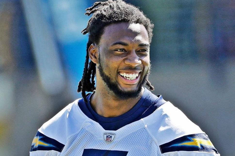 穿著 Chargers 球衣的足球運動員在戶外燦爛微笑。